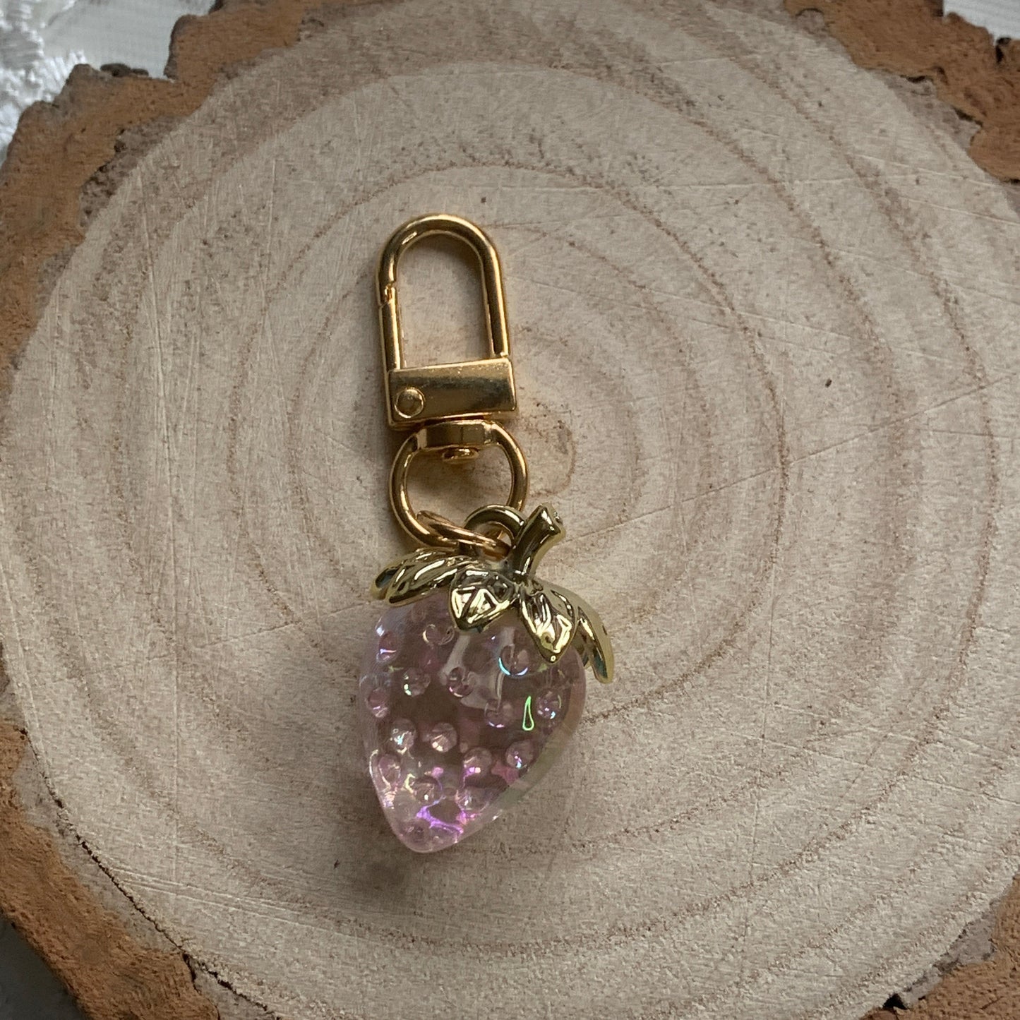 Gold keychain with a pink strawberry