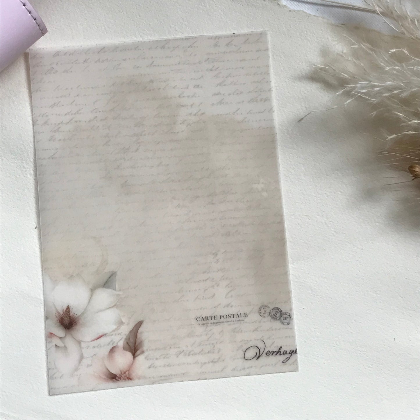 Stationery item with floral design on a vellum with script background